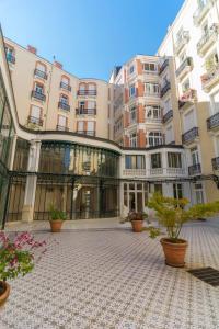 a large building with potted plants in front of it at L incomparable - International Palace in Vichy