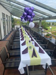 a long table with purple and purple balloons on it at M13 Hotel in Riol
