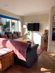 ein Wohnzimmer mit einem Sofa und einem TV in der Unterkunft Annexe Newnham in Daventry