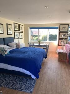a bedroom with a blue bed and a window at Annexe Newnham in Daventry