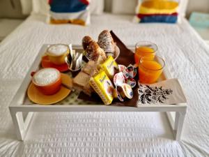 una bandeja de alimentos para el desayuno y bebidas en una cama en SAINT GEORGE'S HOUSE Bari en Bari