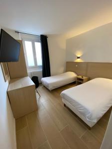 マルセイユにあるHôtel Raphael Pradoのベッド2台、薄型テレビが備わるホテルルームです。