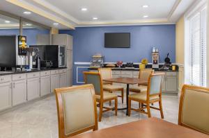 a kitchen with a table and chairs and a tv at Days Inn by Wyndham Kingsland GA in Kingsland