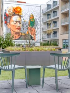 a table and two chairs in front of a mural at limehome Münster Von-Steuben-Str - Digital Access in Münster