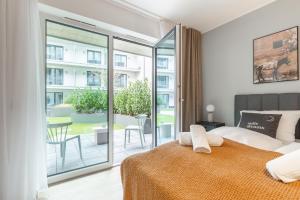 a bedroom with a king sized bed and a balcony at Limehome Münster Von-Steuben-Str - Digital Access in Münster