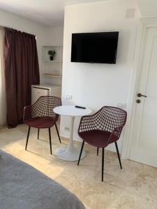 Habitación con 2 sillas, mesa y TV. en Dacia Residence Apartments en Bucarest