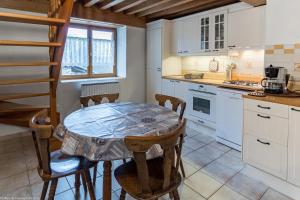a kitchen with a table and chairs in a room at La Maisonnette in Chaudenay-le-Château