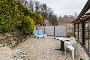 two chairs and a table on a gravel patio at La Maisonnette in Chaudenay-le-Château
