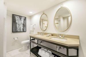 a bathroom with a sink, mirror, and toilet at Galt House Hotel, A Trademark Collection Hotel in Louisville