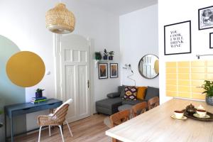 ein Wohnzimmer mit einem Tisch und einem Sofa in der Unterkunft BpR Pastellion Art Home in Buda in Budapest