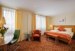 GAIA Hotel Basel - the sustainable 4 star hotel في بازل: غرفة الفندق بسرير وطاولة