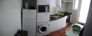 a kitchen with a refrigerator and a washing machine at Casa Mateus - Colares, Parque Natural Sintra Cascais in Sintra