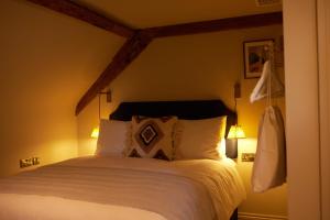 a bedroom with a large bed with two lamps at The Bell & Crown in Zeals