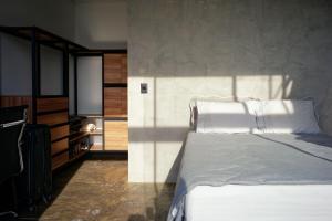 a bedroom with a bed with white pillows at Casa Nuvem Lotf House + Suíte in Alto Paraíso de Goiás