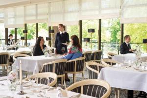 a group of people sitting at tables in a restaurant at Maritim Hotel Bad Homburg in Bad Homburg vor der Höhe