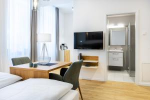 a living room with a table and a television in a room at Ferienapartments am Krusespeicher Ferienapartments am Krusespeicher 0-01 in Wismar