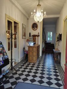 a man sitting at a desk in a room with a checkered floor at Hotel des Voyageurs in Rocamadour