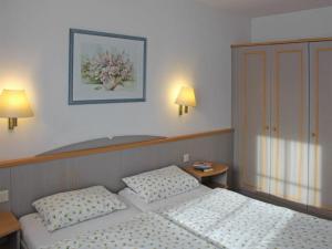 1 dormitorio con 2 camas y una foto en la pared en Ferienhaus Nr 48, Kategorie Komfort, Feriendorf Hochbergle, Allgäu, en Bichel