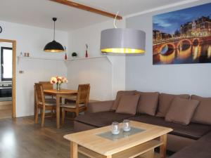 uma sala de estar com um sofá e uma mesa em Ferienhaus Nr 12, Kategorie Komfort, Feriendorf Hochbergle, Allgäu em Bichel