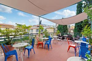 a patio with tables and chairs on a balcony at Hotel Azzi in Florence
