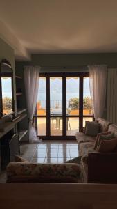 - un salon avec un canapé et de grandes fenêtres dans l'établissement Few steps to the heart of Menaggio, swimming pool, breathtaking view, à Menaggio