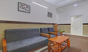 a waiting room with a couch and chairs and a table at Treebo Trend Thoduvas Star Plaza Cochin Airport in Nedumbassery
