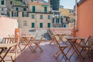 un gruppo di tavoli e sedie su un balcone di Banchi a Riomaggiore