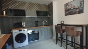 a kitchen with a sink and a dishwasher and a table at Coeur de ville, calme, spacieux,Parking et wifi ! in Chartres