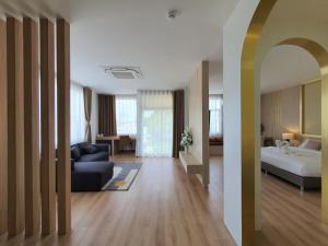 a living room with a couch and a bed in a room at Lueangchan Orchid Hotel in Chanthaburi