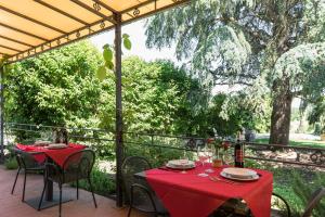 un patio con 2 mesas con manteles rojos. en Agriturismo IL GREPPO, en Abbadia di Montepulciano