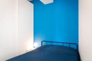 een blauwe slaapkamer met een bed en een spiegel bij Appartamento Miramare in Portoferraio