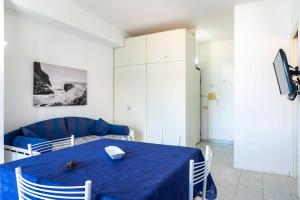 comedor con mesa azul y sofá en Appartamento Miramare, en Portoferraio
