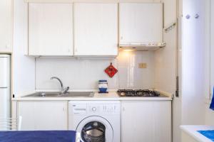 een keuken met een wasmachine en een wastafel bij Appartamento Miramare in Portoferraio