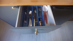 a drawer filled with blue utensils in a cabinet at Coeur de ville, calme, spacieux,Parking et wifi ! in Chartres
