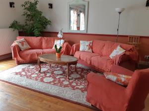 een woonkamer met rode banken en een tafel bij Les tilleuls in Épernay-sous-Gevrey