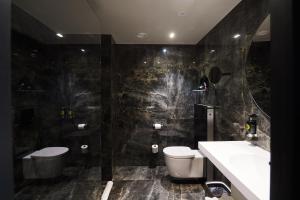 uma casa de banho com um WC, um lavatório e um espelho. em Harmon House em Bruxelas