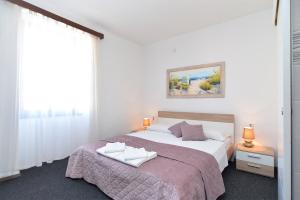 ein weißes Schlafzimmer mit einem großen Bett und einem Fenster in der Unterkunft Rooms Bale 2150 in Bale