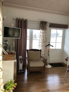 uma sala de estar com uma cadeira e uma televisão de ecrã plano em Wonderful cottage by the lake em Hautjärvi