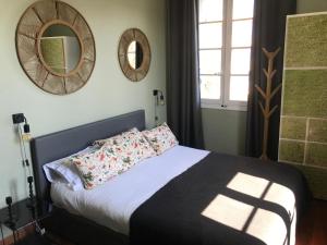a bedroom with a bed and a mirror at La chambre de Toutou in Bastia