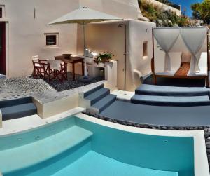 - une piscine avec des escaliers et une table avec un parasol dans l'établissement Abelis Canava Luxury Suites, à Vóthon