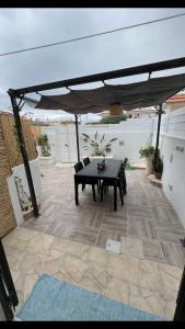 une terrasse avec une table et un parasol dans l'établissement Holiday Rooms Ninfa, à Avola