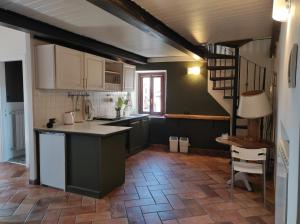 eine Küche mit weißen Schränken und eine Treppe in einem Zimmer in der Unterkunft Piazza Duomo casa vacanze in Sutri