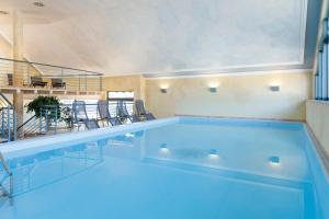 a large swimming pool with blue water in a room at Hotel Rose in Baiersbronn