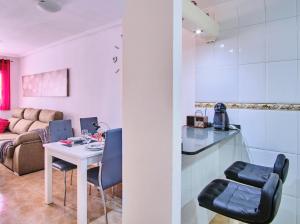 een keuken en een woonkamer met een tafel en stoelen bij Espanatour EUROPA in Torrevieja