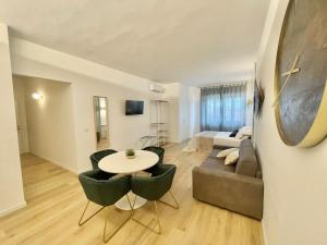 uma sala de estar com um sofá, uma mesa e cadeiras em Barirooms - Picca 24 em Bari