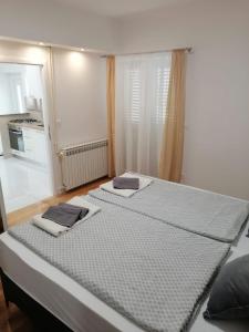 two beds in a room with a kitchen at Apartments Niko in Novalja