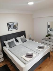 a white bedroom with a large bed with two pillows at Apartments Niko in Novalja