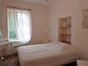 a white bedroom with a bed and a window at 6EGA14 Superbe maison Familiale 6 personnes in Collioure