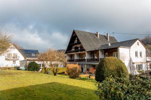 una gran casa blanca con techo negro en Hotel Tiefenhagen Sauerland, en Lennestadt