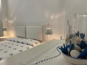 ein Schlafzimmer mit einem Bett und einer Schüssel Blumen auf einem Tisch in der Unterkunft B&B Vie del Mediterraneo in Porto Cesareo